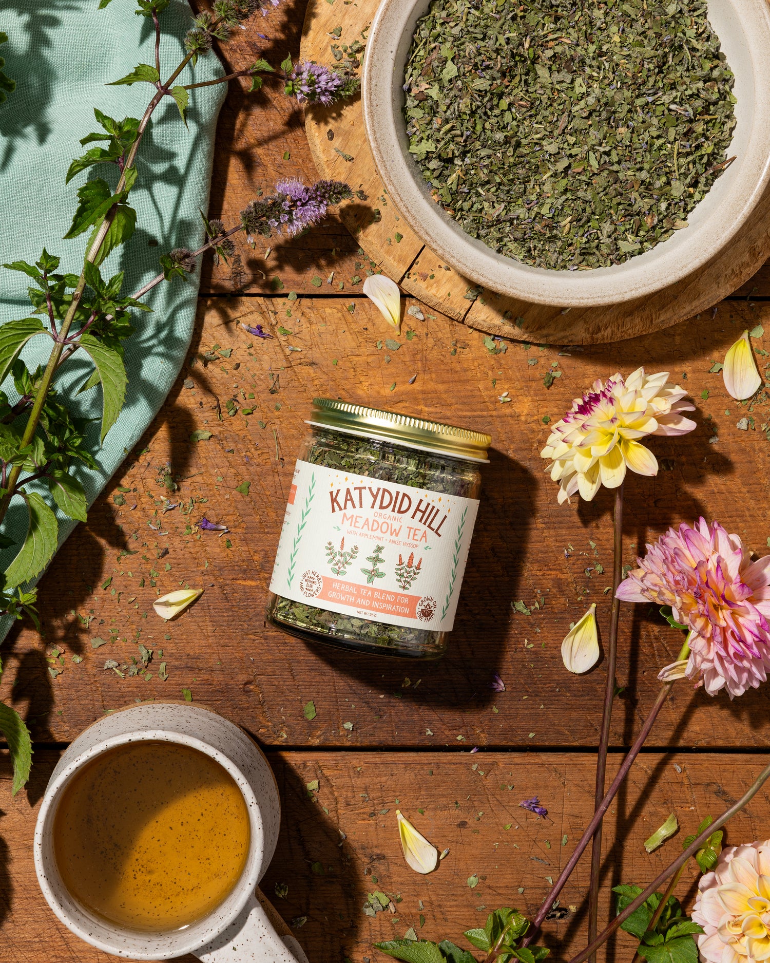 meadow tea on wood background with loose leaf bowl and cup of tea