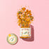 glass jar of calendula flowers on to pink background.