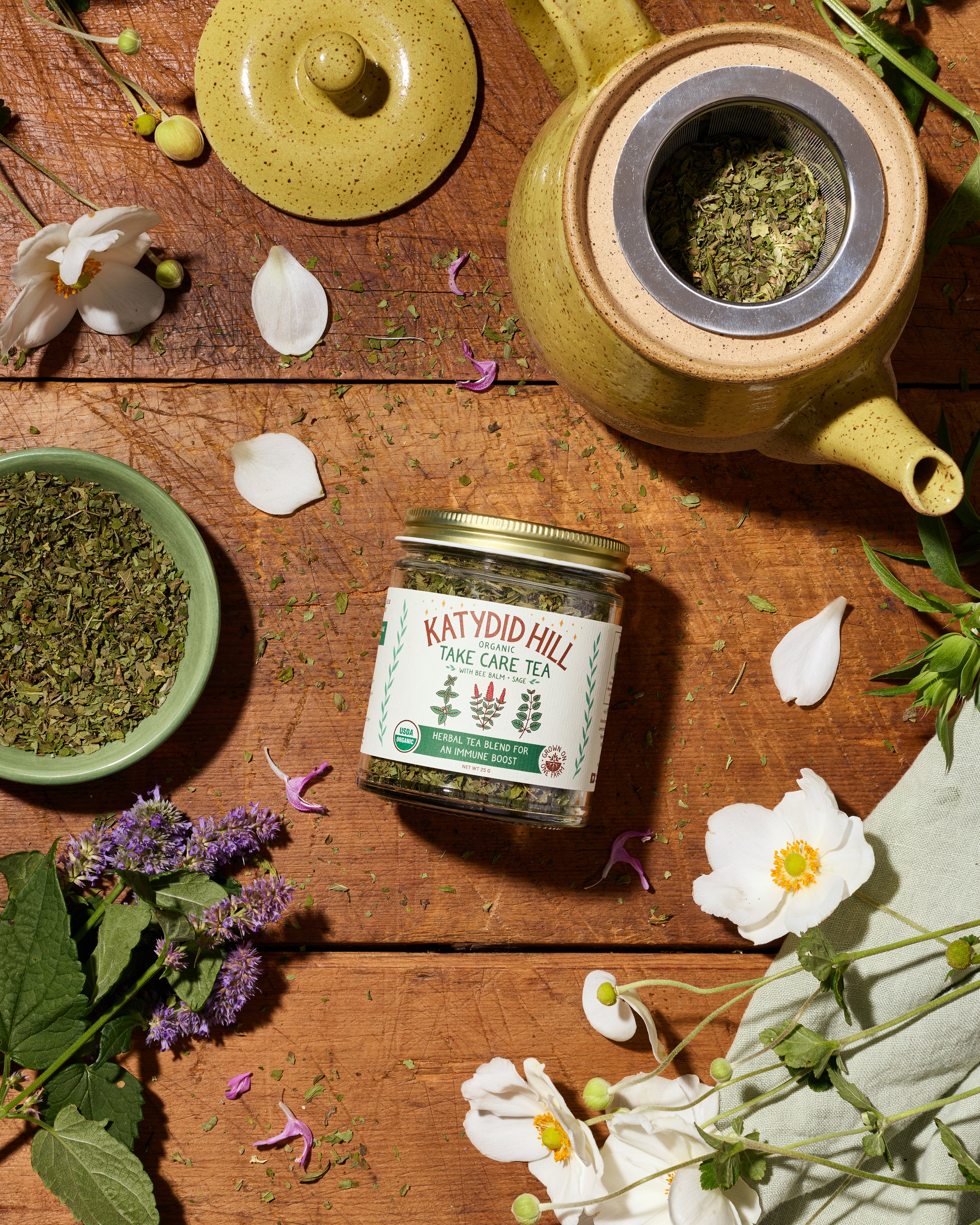 Take care tea with bee balm and sage in glass jar. Herbal tea blend for an immune boost. Loose leaf tea shown in a bowl.