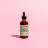 bottle of poppy dreams elixir on pink background