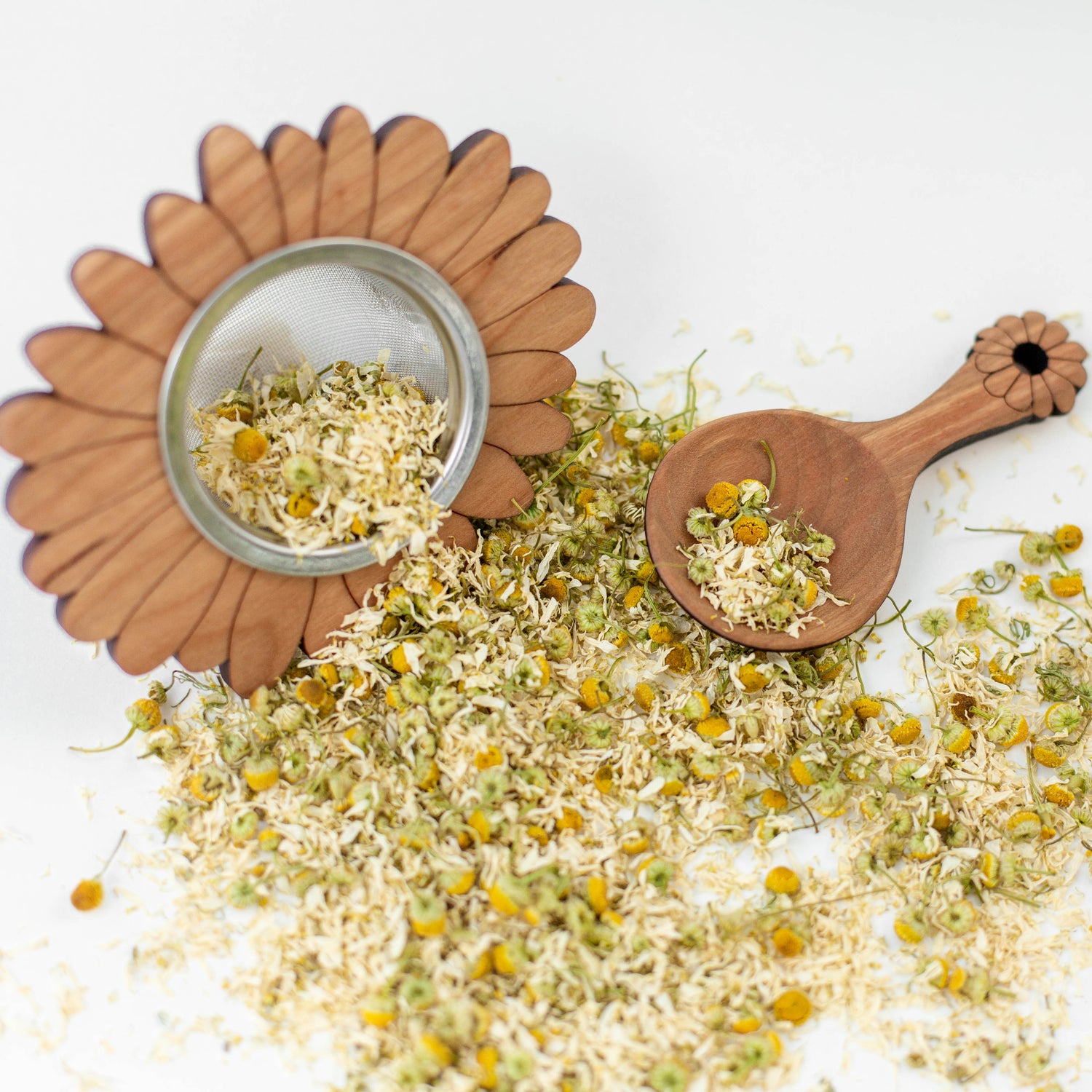 wooden tea strainer with tea scoop and chamomile tea