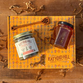 Herbal tea jar, honey jar, and honey stick on top of a gift box