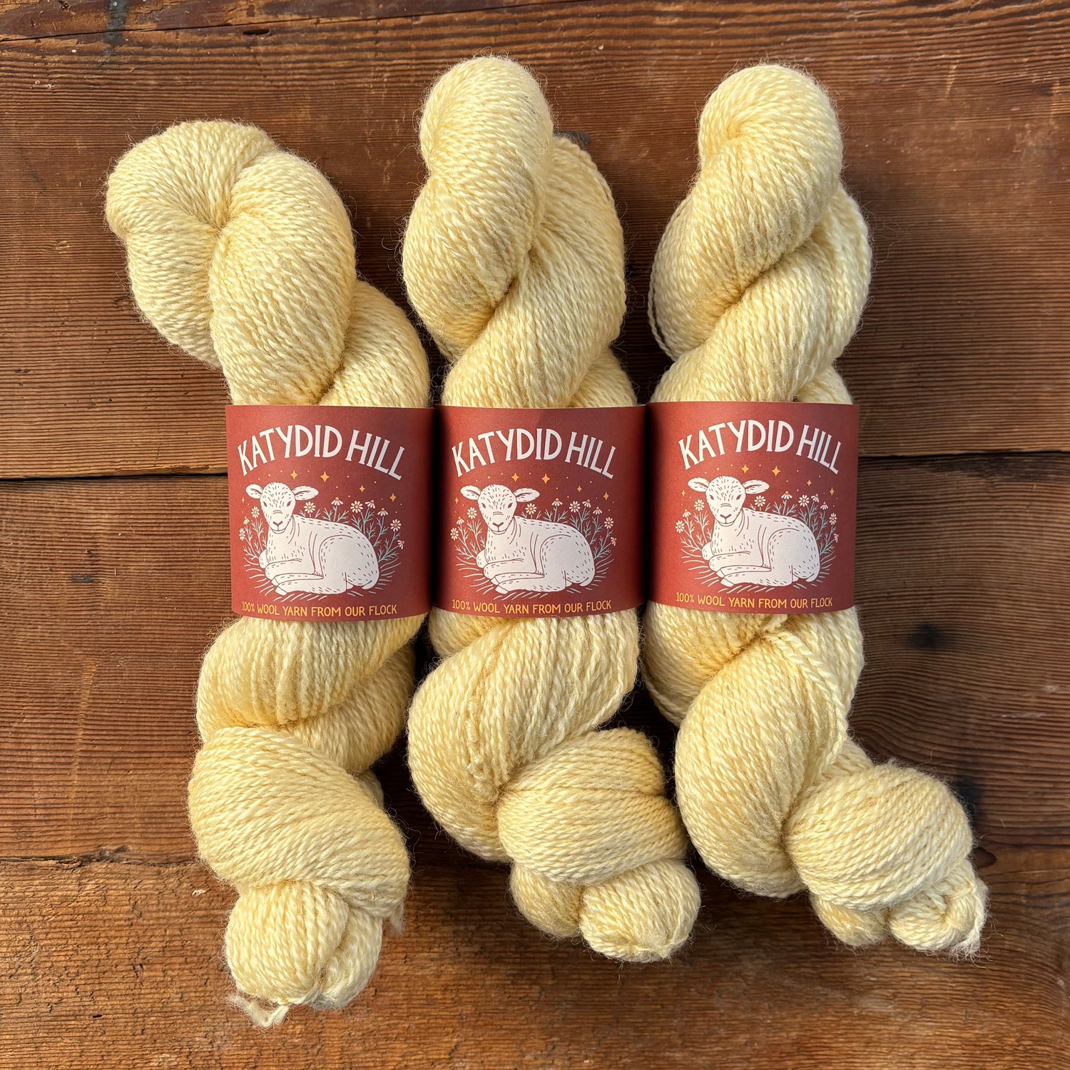 Three skeins of light yellow yarn with &