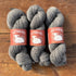 Grey yarn on a wood background.