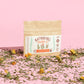 sunshine tea sample pack with loose herbs and pink background