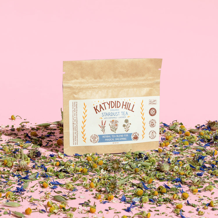 stardust tea sample pack with loose herbs and pink background
