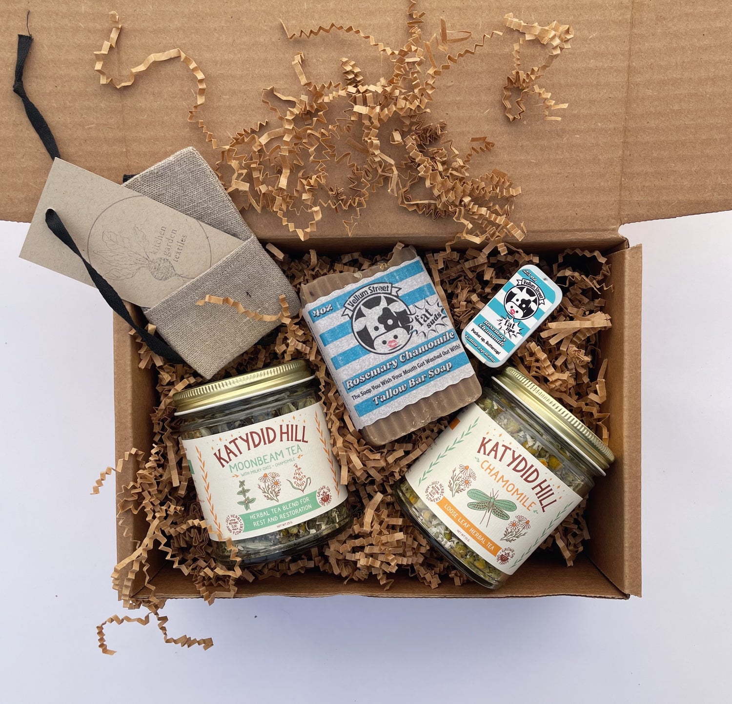 Chamomile themed gift box with handmade tallow soap and lip balm, chamomile tea and moonbeam tea blend, and reusable linen tea bag